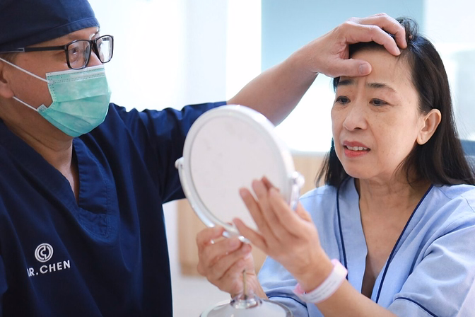 DCH Doctor Examining A Woman Holding A Mirror